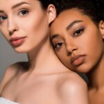 portrait of tender multicultural women with clean skin, isolated on grey